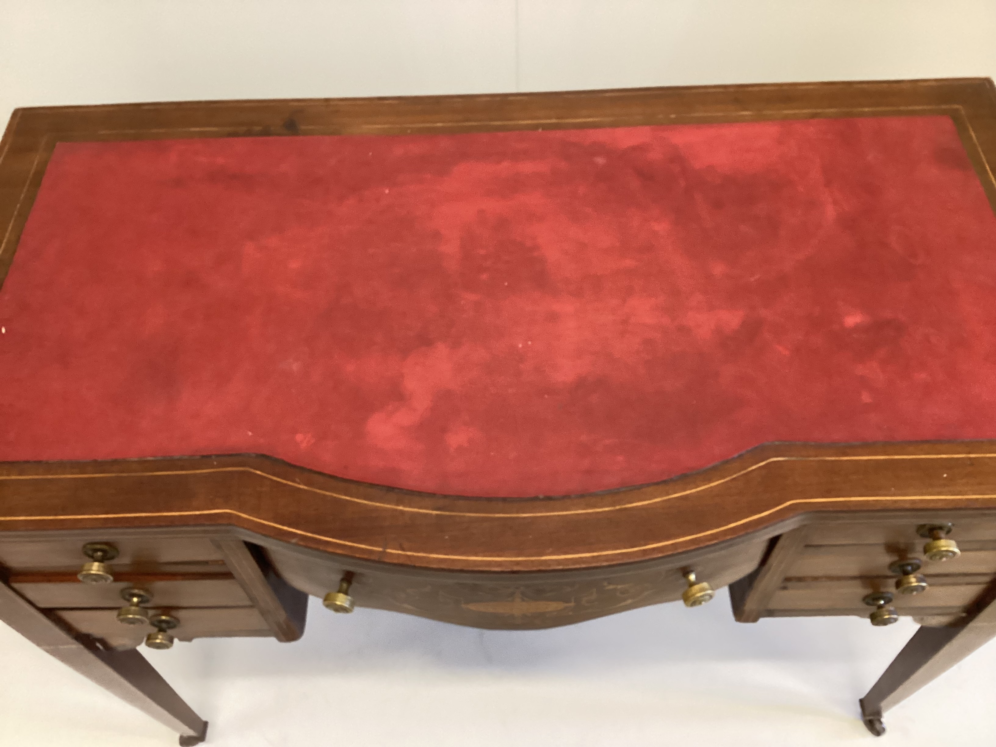 An Edwardian inlaid mahogany bowfront kneehole writing table, width 99cm, depth 52cm, height 73cm